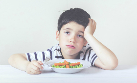 little kid unhappy at dinner